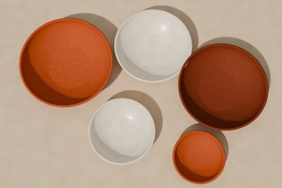Five handmade bowls in terracotta, clay and cream glaze, seen from above on linen